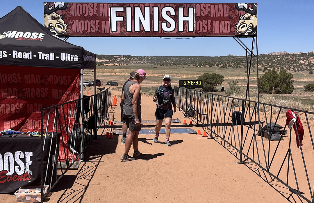 Students crossing a finish line during a trail run race