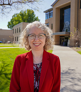 Smiling woman in red blazer outside