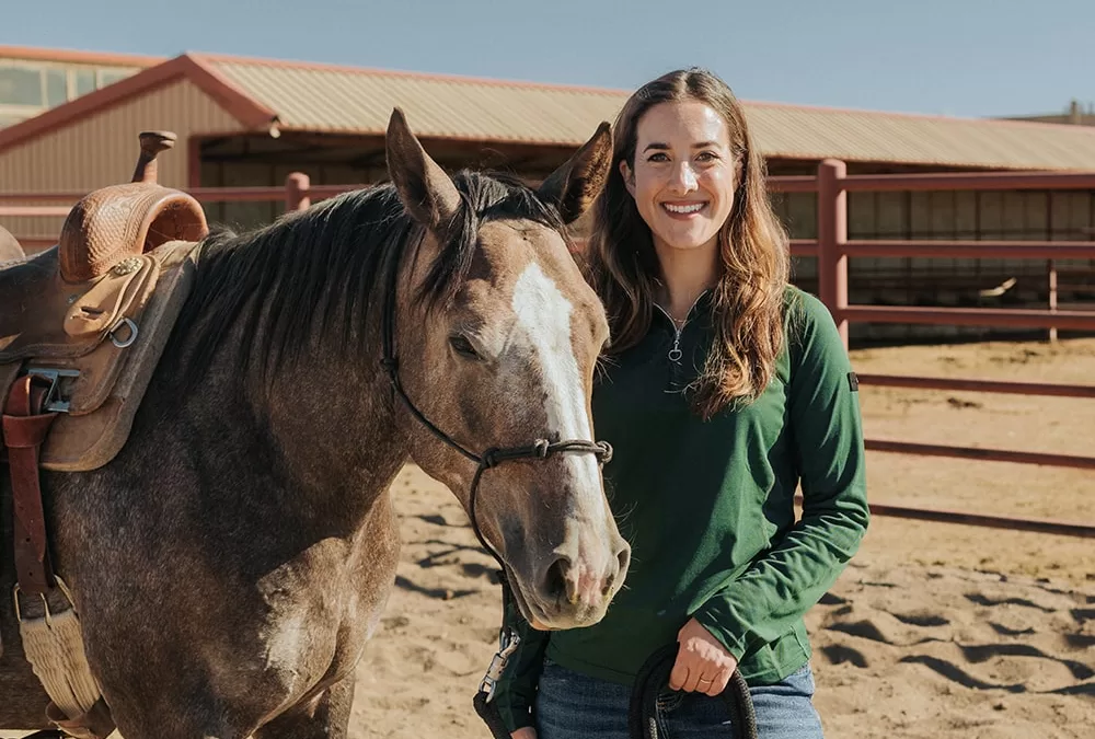 College of Ag Sciences alum, Devan Catalano, stands next to a horse.