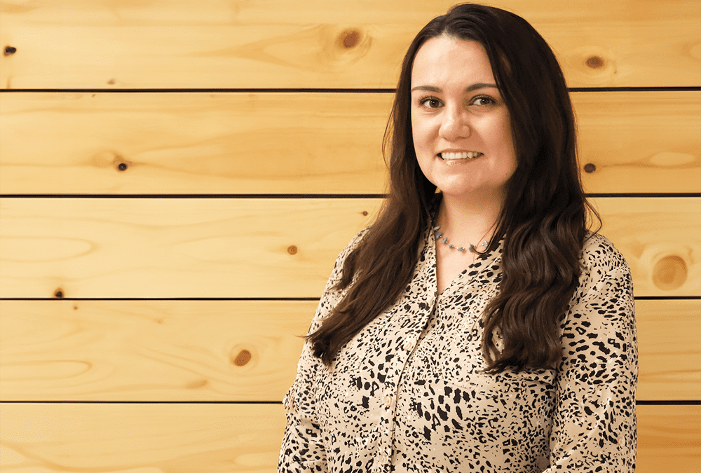 Woman standing in front of a wood wall