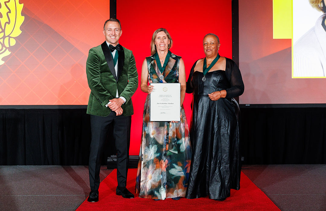 Lori Catalano accepts the ASLA award from two presenters
